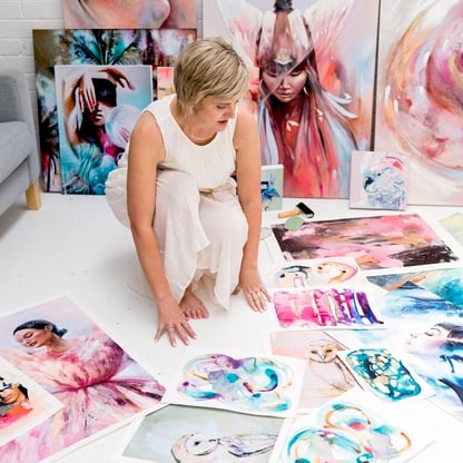Alannah photo girl squating on ground among pink blue painitngs 